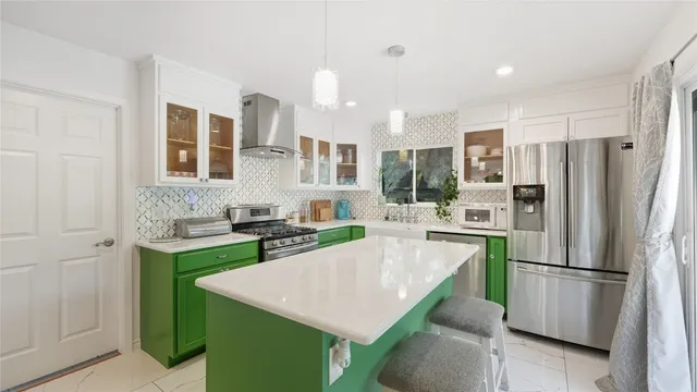 a kitchen with a refrigerator a stove top oven a sink and cabinets