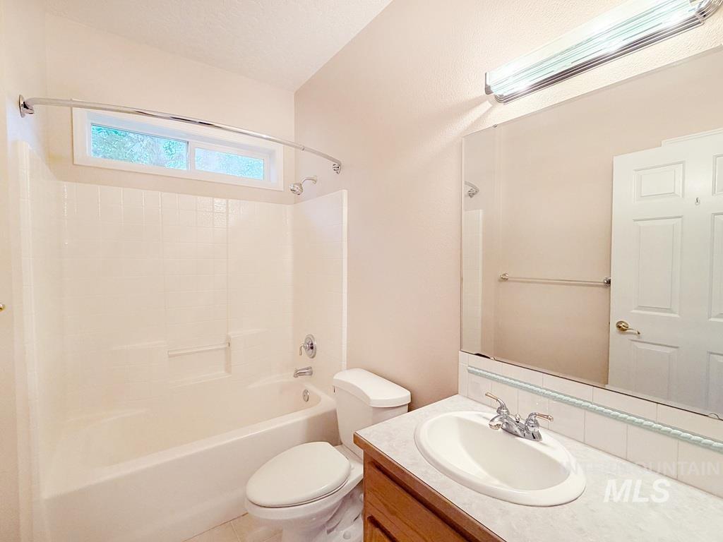 5875 Diamond Ridge Way Nampa, ID 83686 - Photo 18 of 32 Bright, updated bathroom featuring a wood-finish vanity with dual sinks, marble-look countertop, and chrome fixtures