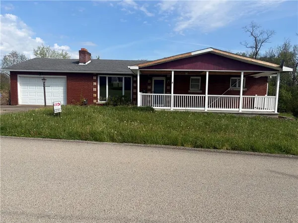 a view of a house with a yard and potted plants