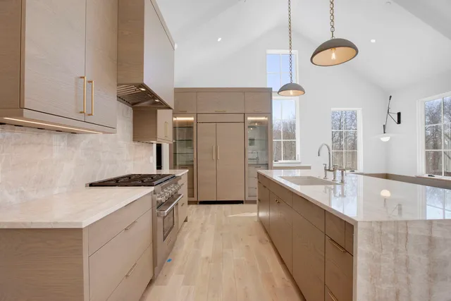 a kitchen with stainless steel appliances granite countertop a sink a stove and a refrigerator