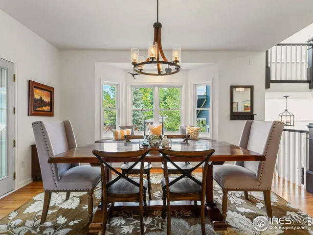 a dining room with furniture a chandelier and wooden floor