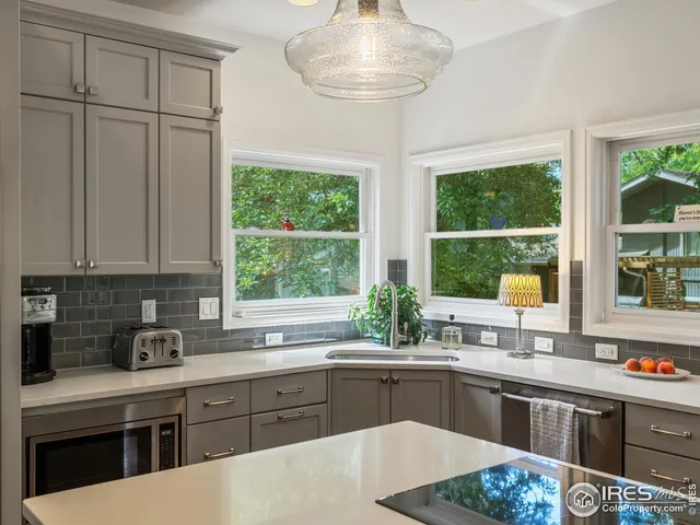 a kitchen with stainless steel appliances granite countertop a sink a stove and a counter space
