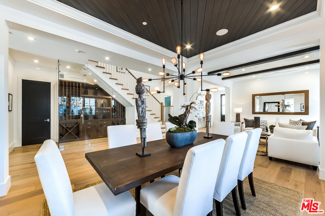 16700 Addison Street Encino, CA 91436 - Photo 11 of 53 a view of a dining room with furniture a chandelier and wooden floor