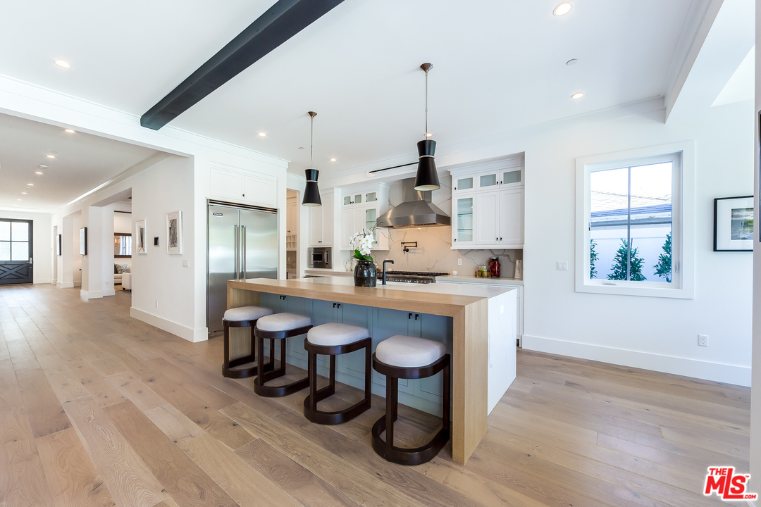 16700 Addison Street Encino, CA 91436 - Photo 13 of 53 a kitchen with stainless steel appliances a dining table chairs and sink