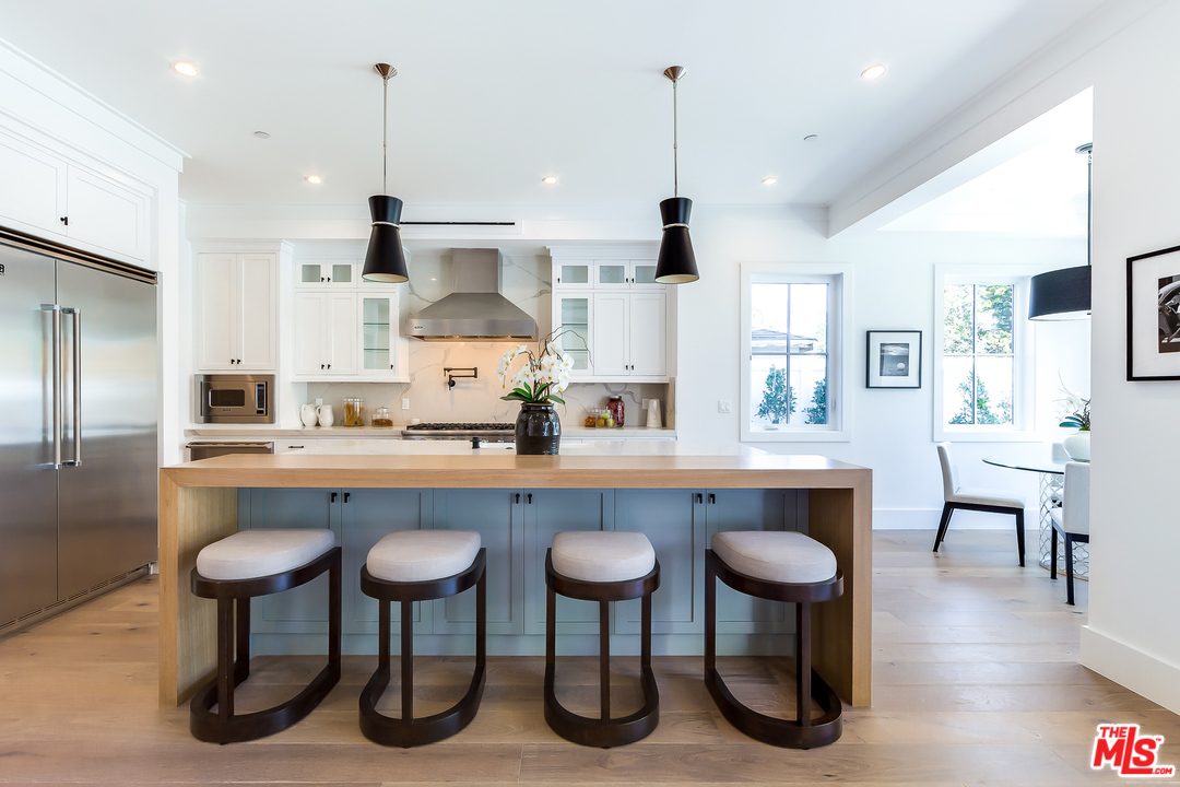 16700 Addison Street Encino, CA 91436 - Photo 14 of 53 a kitchen with stainless steel appliances granite countertop a kitchen island a table and chairs in it