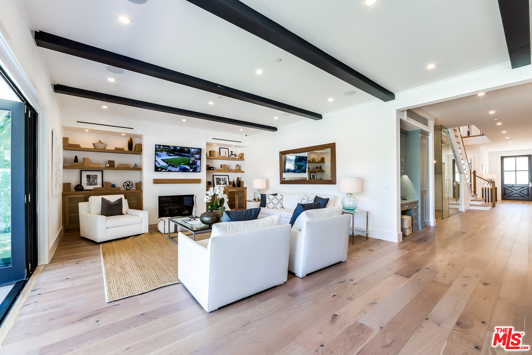 16700 Addison Street Encino, CA 91436 - Photo 19 of 53 a living room with furniture and a wooden floor