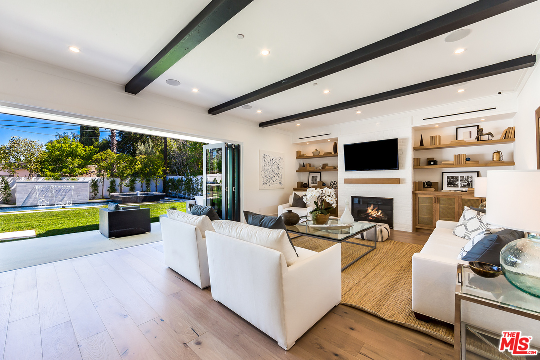 16700 Addison Street Encino, CA 91436 - Photo 20 of 53 a living room with fireplace furniture and a flat screen tv