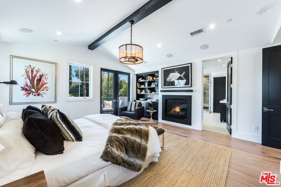 16700 Addison Street Encino, CA 91436 - Photo 31 of 53 a bedroom with a bed and a fireplace