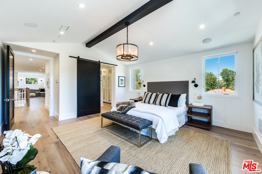 16700 Addison Street Encino, CA 91436 - Photo 32 of 53 a spacious bedroom with a bed a dresser and wooden floor