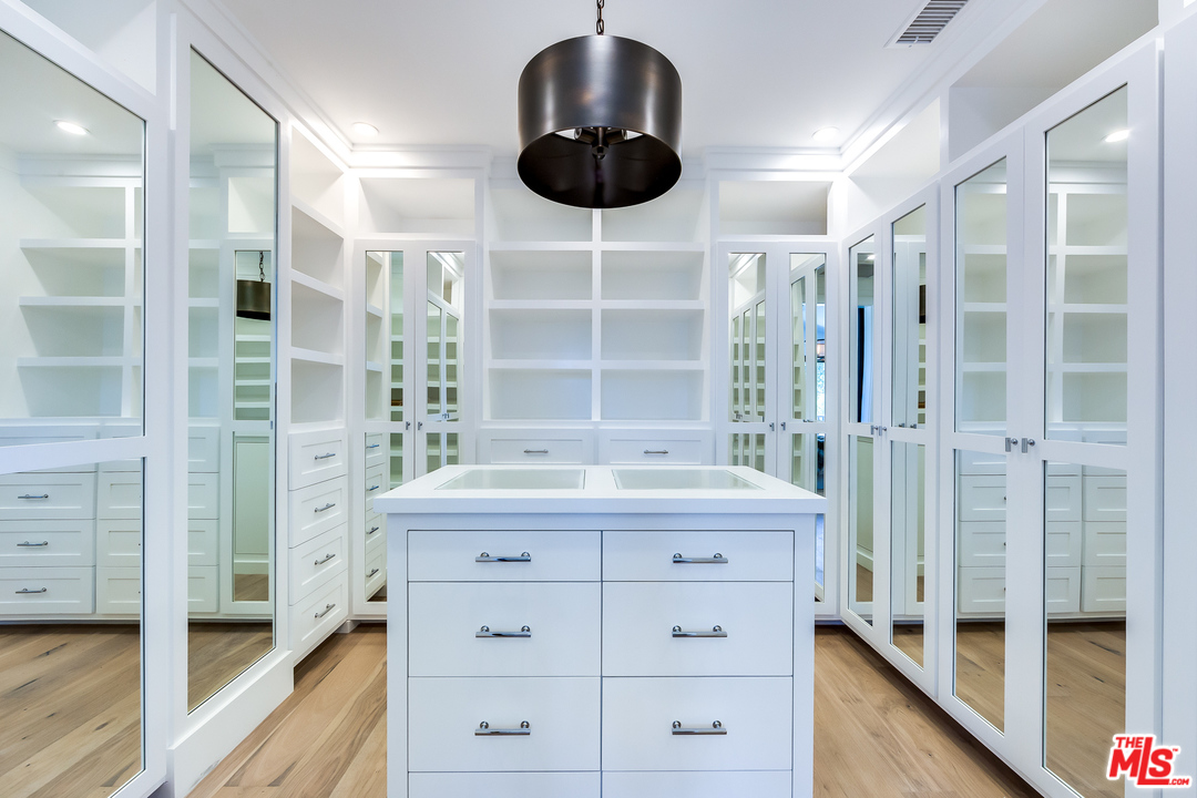 16700 Addison Street Encino, CA 91436 - Photo 35 of 53 a room with a cabinets and a wooden floor
