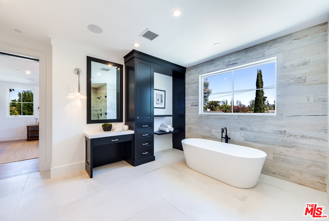 16700 Addison Street Encino, CA 91436 - Photo 37 of 53 a bathroom with a tub a sink and a mirror
