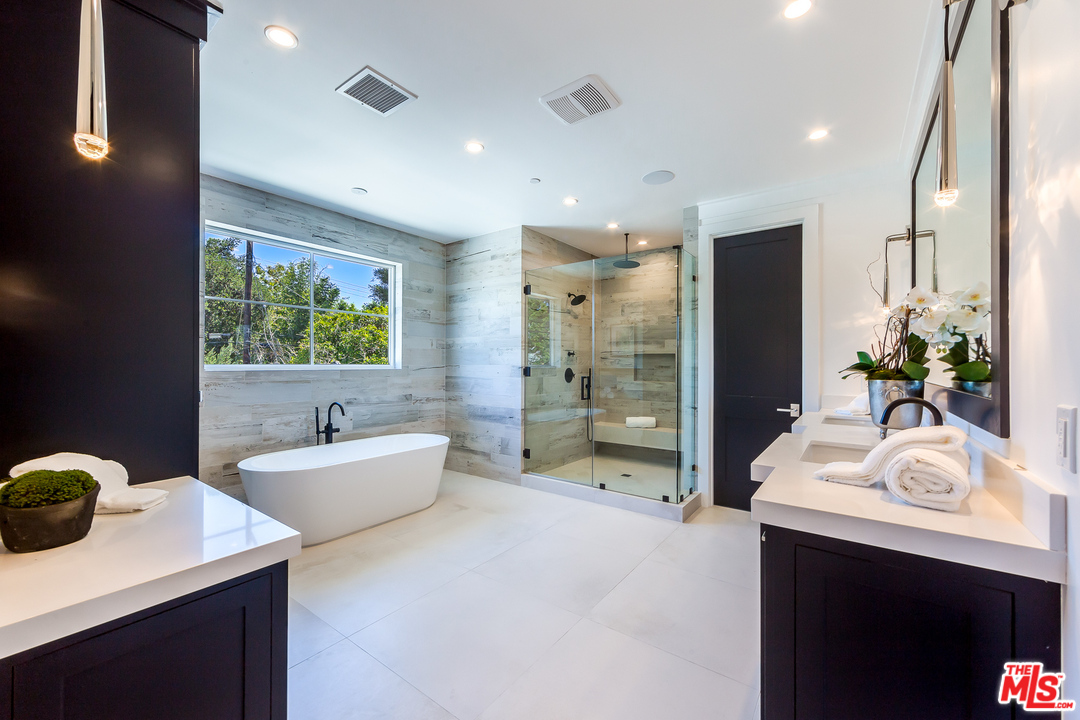 16700 Addison Street Encino, CA 91436 - Photo 39 of 53 a spacious bathroom with a tub sink and mirror