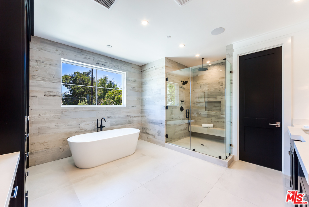 16700 Addison Street Encino, CA 91436 - Photo 40 of 53 a bathroom with a tub sink mirror and toilet