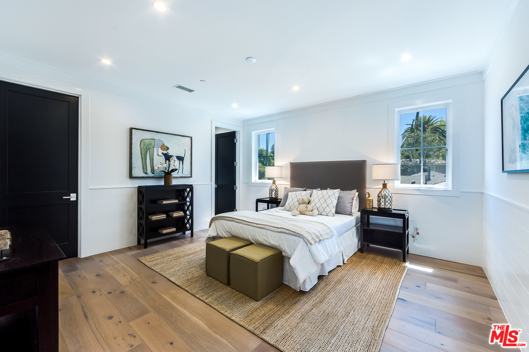 16700 Addison Street Encino, CA 91436 - Photo 42 of 53 a bedroom with a bed and wooden floor