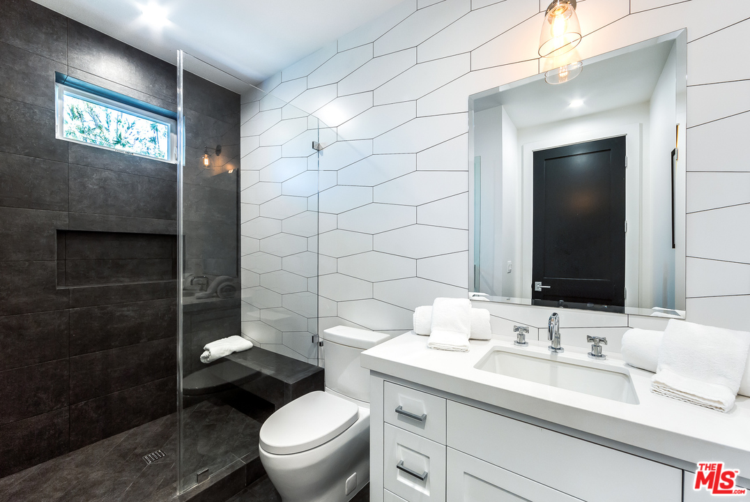 16700 Addison Street Encino, CA 91436 - Photo 47 of 53 a bathroom with a sink a toilet and shower