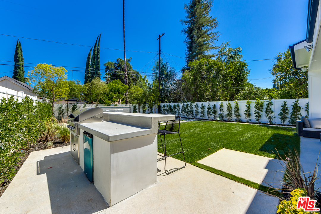 16700 Addison Street Encino, CA 91436 - Photo 52 of 53 a view of a backyard with couches plants and large tree