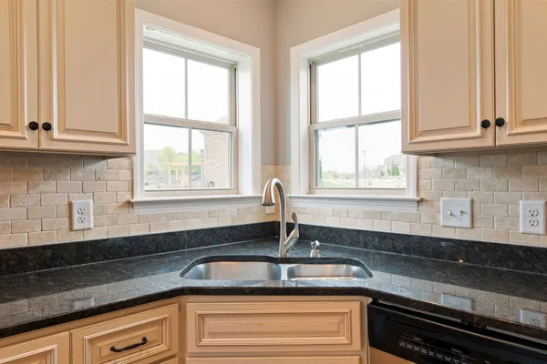 a kitchen with granite countertop white cabinets and a window