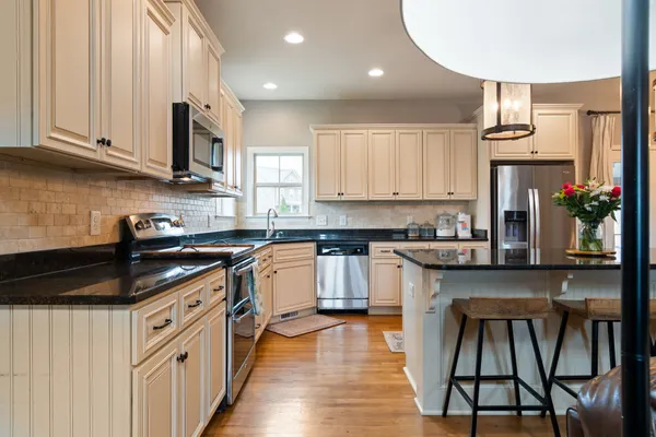 a kitchen with stainless steel appliances granite countertop a stove a sink and a microwave