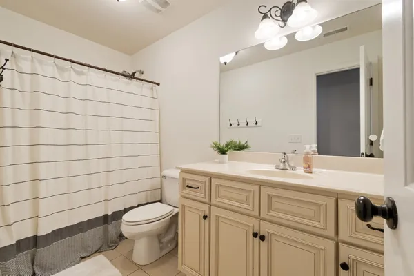 a bathroom with a toilet sink vanity and mirror