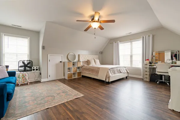 a spacious bedroom with a bed and a chandelier
