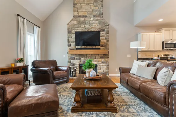a living room with furniture a flat screen tv and a fireplace