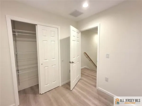 a view of a hallway with wooden floor and entryway