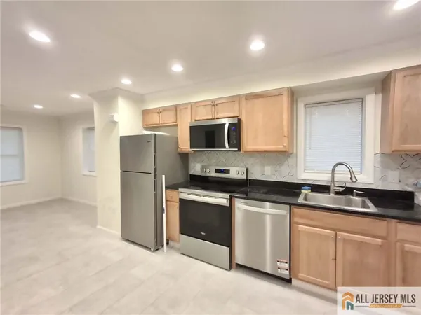 a kitchen with stainless steel appliances granite countertop a stove a sink and a refrigerator