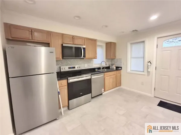 a kitchen with stainless steel appliances a refrigerator and a stove top oven