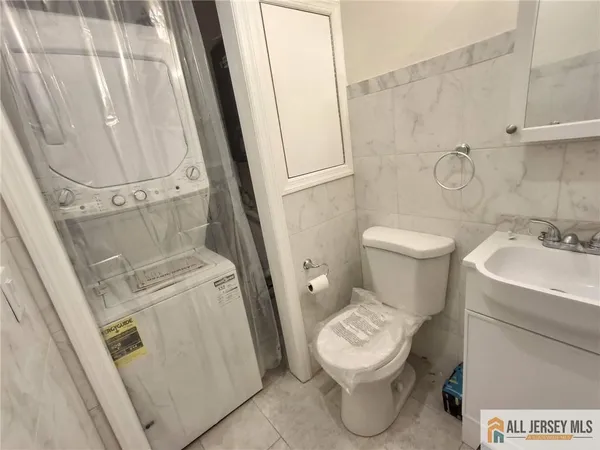 a white toilet sitting next to a white sink and vanity