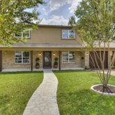 a front view of a house with a yard and trees