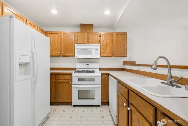 a kitchen with a sink cabinets stainless steel appliances and a window