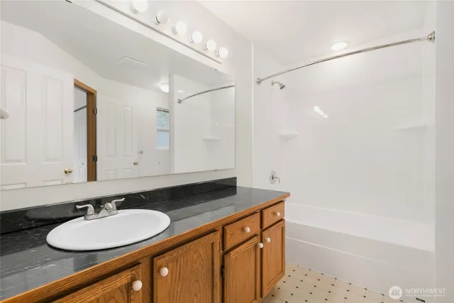a bathroom with a granite countertop sink and a mirror