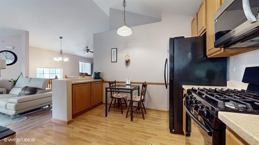 1725 Sienna Court Wheeling, IL 60090 - Photo 11 of 33 a kitchen with stainless steel appliances granite countertop a stove refrigerator and a couch