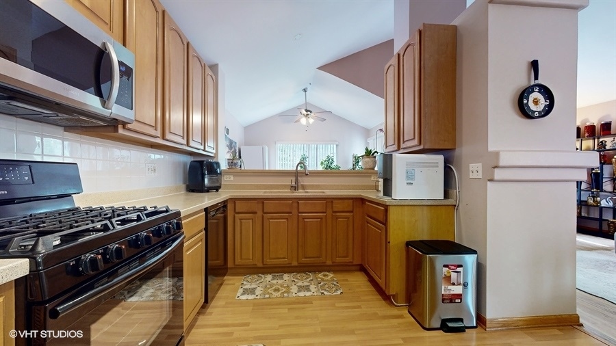 1725 Sienna Court Wheeling, IL 60090 - Photo 12 of 33 a kitchen with stainless steel appliances granite countertop a stove a sink and a microwave