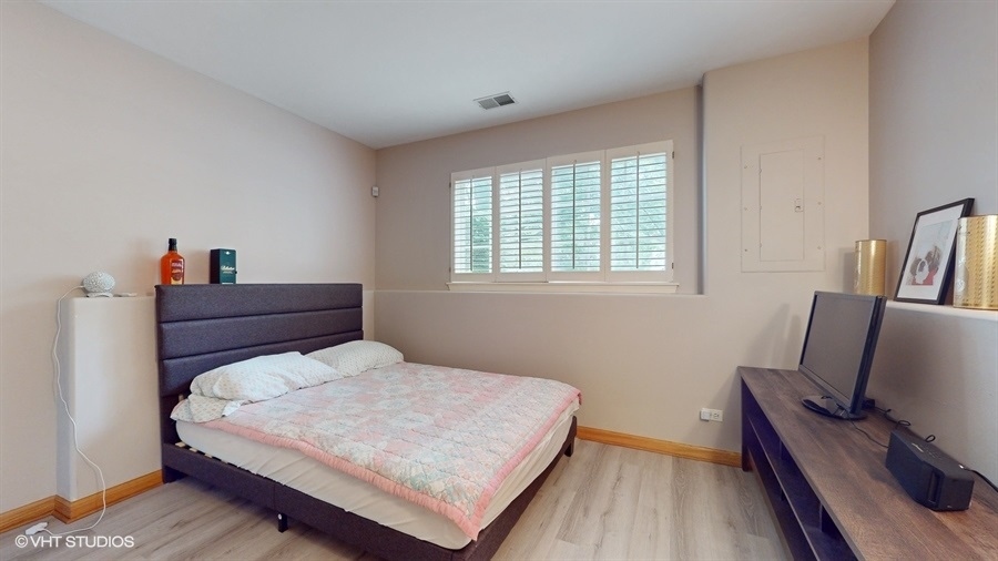 1725 Sienna Court Wheeling, IL 60090 - Photo 22 of 33 a bedroom with a bed and wooden floor