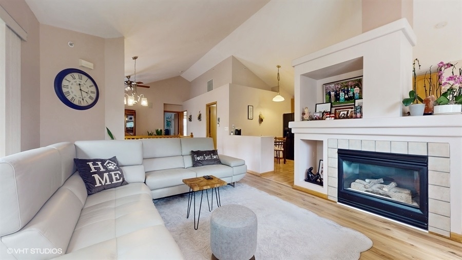 1725 Sienna Court Wheeling, IL 60090 - Photo 5 of 33 a living room with furniture a clock and a fireplace