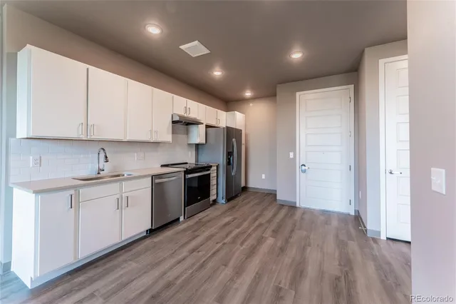 a large kitchen with a lot of white cabinets