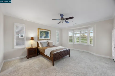 a bedroom with a bed a window and a chandelier