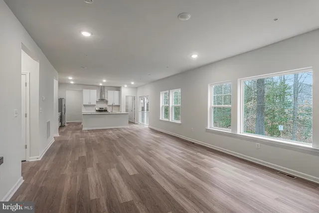 a view of a big room with wooden floor and windows