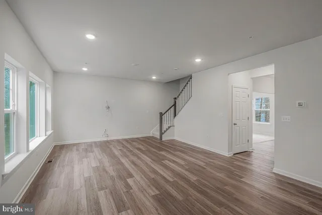 a view of empty room with wooden floor and window