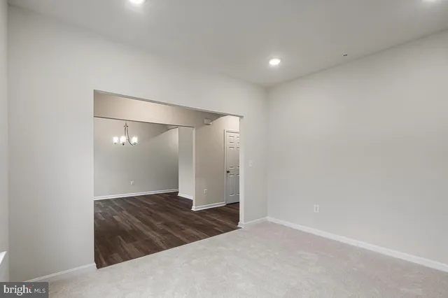 an empty room with wooden floor and mirror