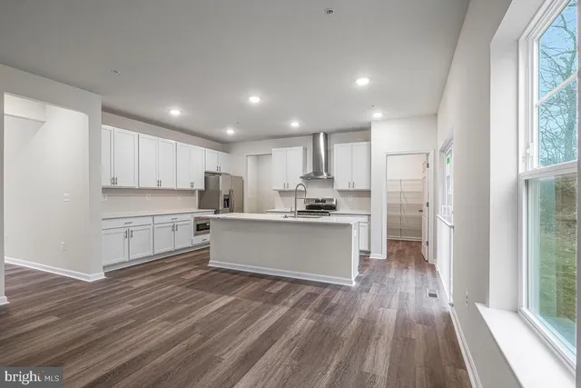 a kitchen with wooden floors and white cabinets