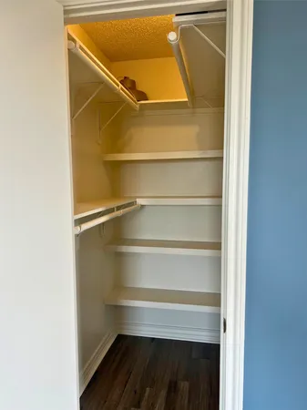 a view of walk in closet with empty racks