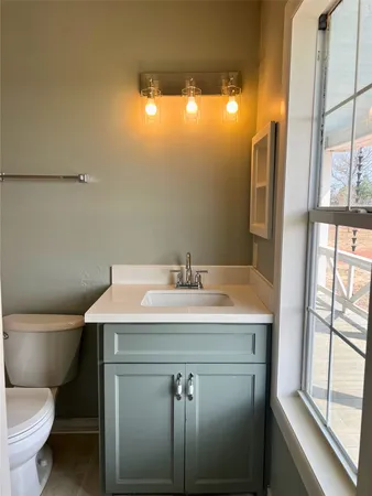 a bathroom with a sink mirror vanity and toilet
