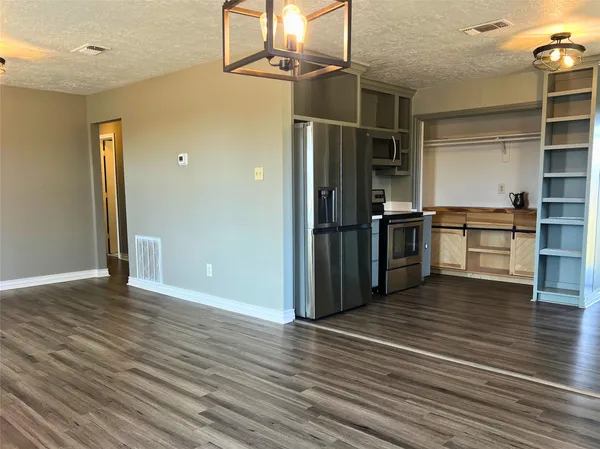 a view of a kitchen with wooden floor and a refrigerator