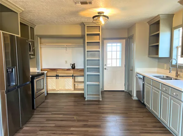 a kitchen with granite countertop a refrigerator and a sink