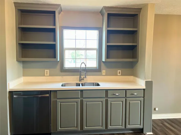 a kitchen with a sink cabinets and a window
