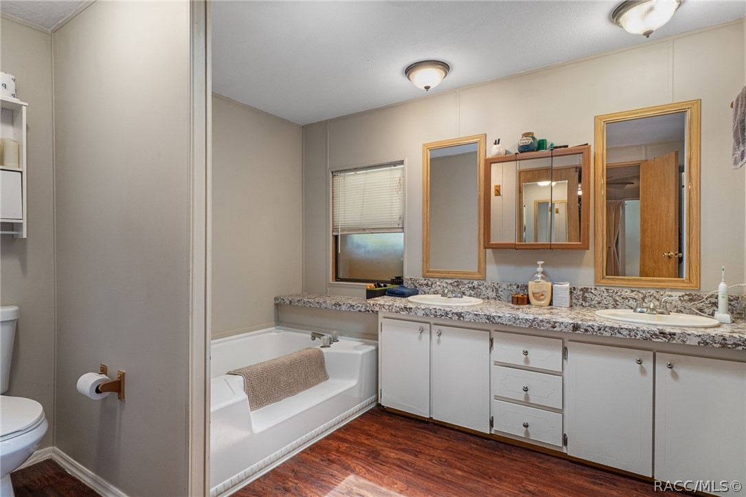 7927 West Cyprian Court Homosassa, FL 34448 - Photo 24 of 40 a bathroom with a double vanity sink and mirror with toilet