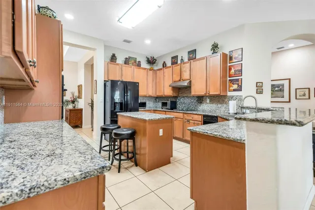 a kitchen with stainless steel appliances granite countertop sink refrigerator and microwave