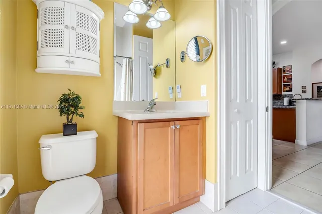 a bathroom with a granite countertop toilet sink and mirror